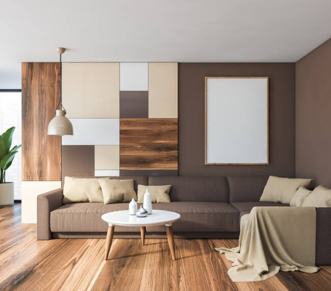 Interior of bright living room with brown and colorful pattern walls, wooden floor, comfortable brown sofa and round coffee table. Vertical mock up poster frame. 3d rendering